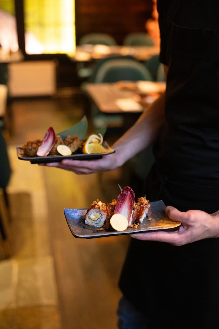 Bediening serveert sushi bij Ocean Paradise